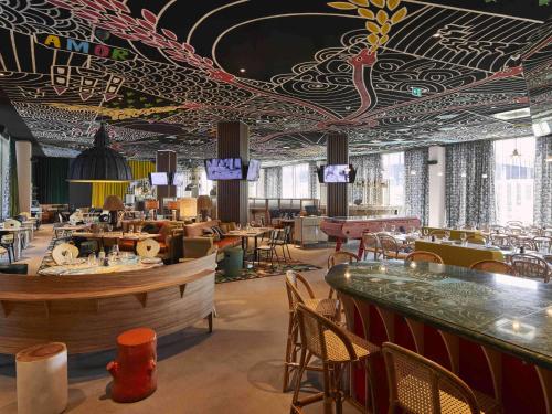 a restaurant with a bar and tables and chairs at Mama Shelter Luxembourg in Luxembourg