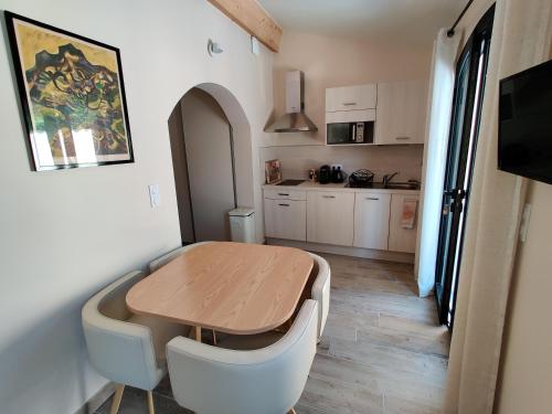 una piccola cucina con tavolo in legno e una sala da pranzo di Gîte Pavillon Arcadia a Vaison-la-Romaine