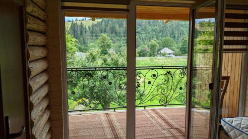 eine Glastür zu einem Balkon mit Aussicht in der Unterkunft Gostynna Rodyna in Izky