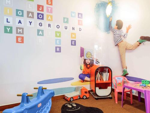a childs room with a wall with alphabet wallpaper at Novotel Porto Gaia in Vila Nova de Gaia
