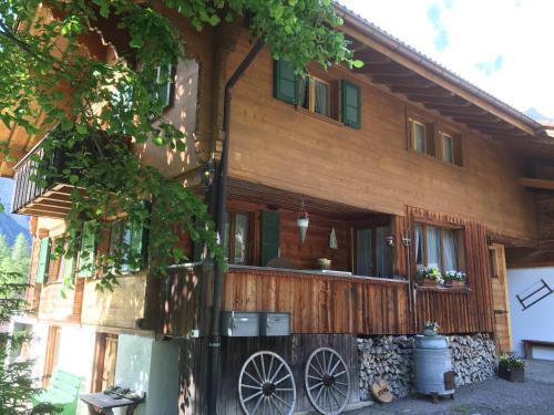 a wooden house with a wooden fence in front of it at Ferienwohnung Lindenheim in Kandersteg