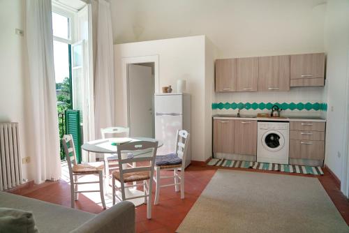 una cucina con tavolo, frigorifero, tavolo e sedie di Villa Ulisse a Ercolano
