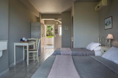 a bedroom with two beds and a desk and a table at Panorama Fanari studios and apartments in Argostoli