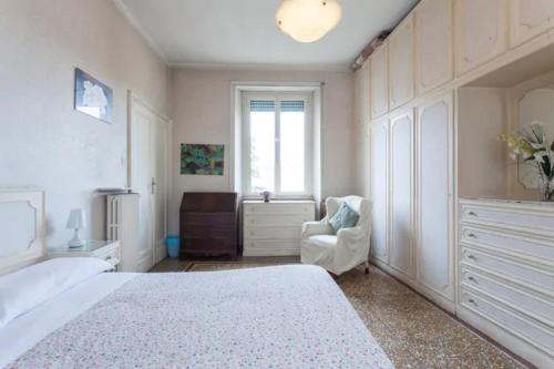 una camera con un letto bianco e una sedia di Chez Liviana a Roma