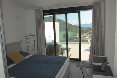 カンニジョネにあるMT Consulting Vacanzeのベッドルーム1室(ベッド1台付)、スライド式ガラスドアが備わります。