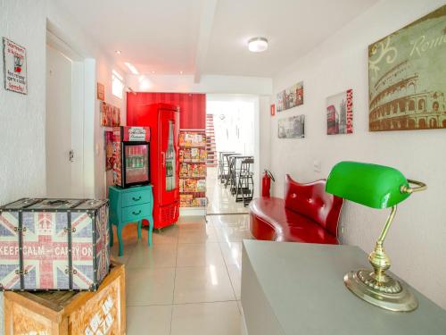 uma sala de estar com um candeeiro verde e um frigorífico vermelho em OYO Hotel Vintage, São Paulo em São Paulo