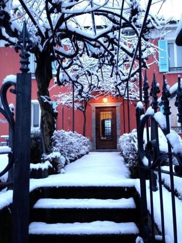 a snow covered stairway leading to a red building at B&B villa sempreverde in Locarno