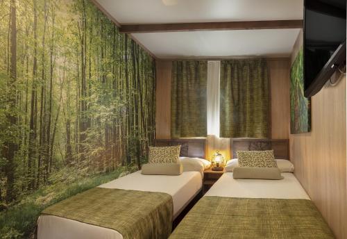 a bedroom with two beds and a wall mural at Magic Robin Hood in Albir
