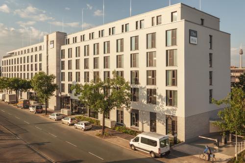 a white building with a van parked in front of it at Holiday Inn - the niu, Leo Nuremberg by IHG in Nürnberg