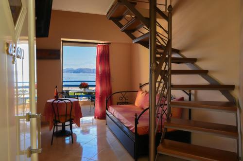 a bedroom with a bunk bed and a spiral staircase at Akrogiali in Míloi