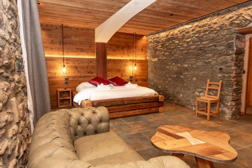 um quarto com uma cama e um sofá num quarto em Hotel K2 em Sauze dʼOulx