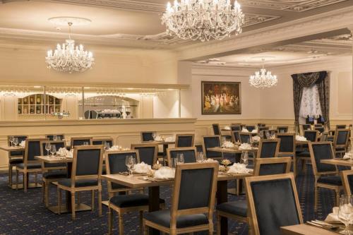 a dining room with tables and chairs and chandeliers at Château Šanov in Šanov