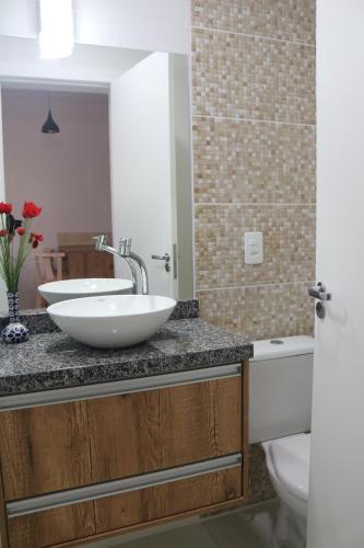 La salle de bains est pourvue d'un lavabo et de toilettes. dans l'établissement Nosso Cantinho Canasvieiras, à Florianópolis