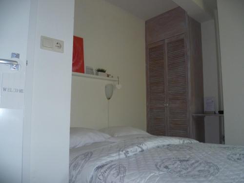 a bedroom with a bed and a wooden door at Hotel Pension Oranje in Valkenburg