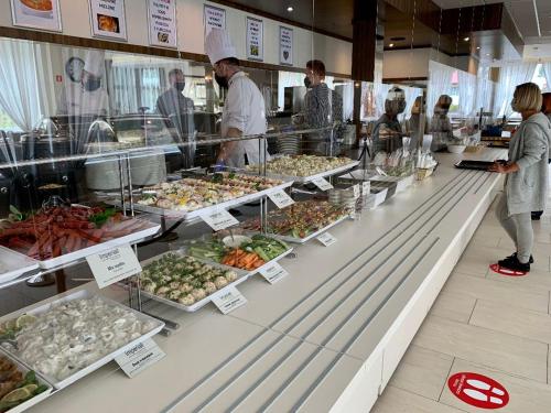 een groep mensen die in de rij staan bij een buffet met eten bij Imperiall Resort & MediSpa in Ustronie Morskie