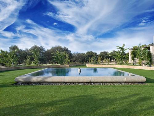 una gran piscina en un campo de césped con un cielo en Hotel Caserio Aldeallana, en Segovia