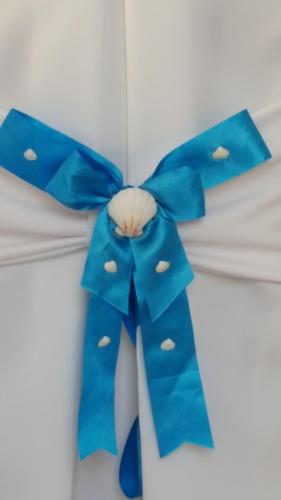 a blue bow on top of a white bed at TINOS AQUA PALAZZO in Tinos Town