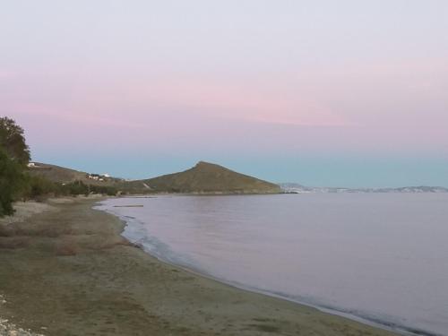 a body of water with a mountain in the background at TINOS AQUA PALAZZO in Tinos Town