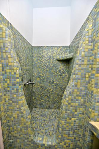 a bathroom with a shower with blue and yellow tiles at TINOS AQUA PALAZZO in Tinos Town