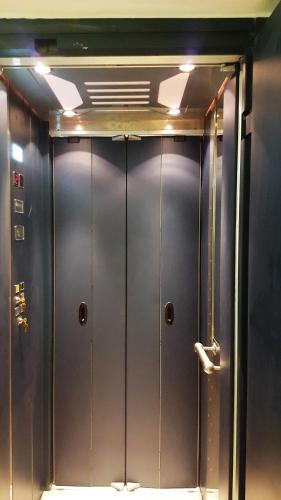 a row of metal elevator doors in a room at TINOS AQUA PALAZZO in Tinos Town