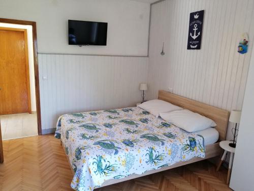 a bedroom with a bed and a tv on the wall at Studio apartment Vigo - Rijeka in Rijeka