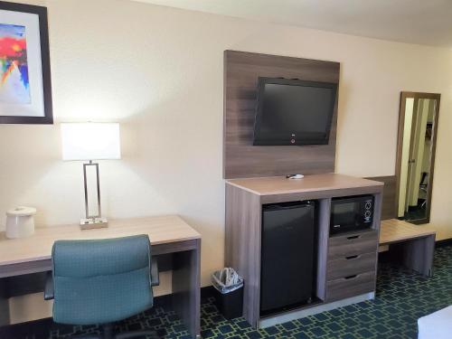 a hotel room with a desk and a tv and a chair at Baymont by Wyndham Santa Fe in Santa Fe