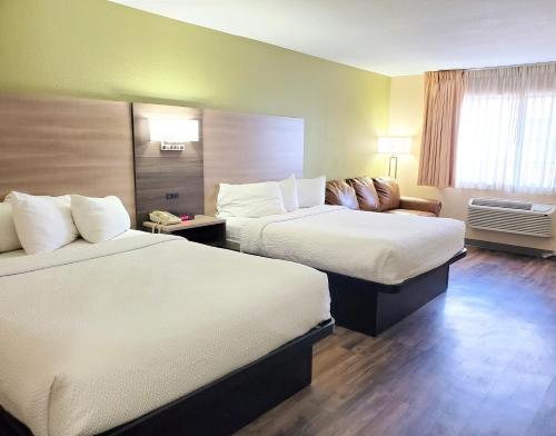 a hotel room with two beds and a couch at Baymont by Wyndham Santa Fe in Santa Fe