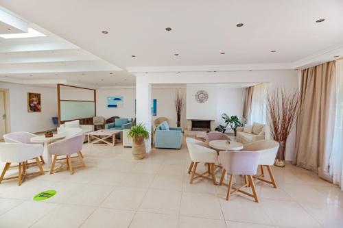 a large living room with tables and chairs at Elani Bay Resort in Siviri