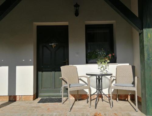 two chairs and a table in front of a door at Rábagyarmati Apartman II in Rábagyarmat