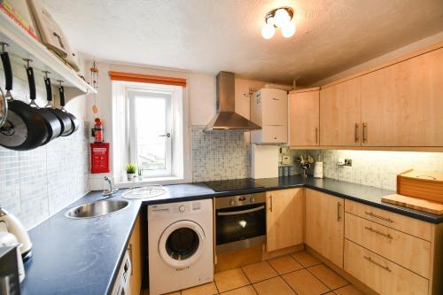 a kitchen with a sink and a washing machine at Brae View Coastal Gem in Largs