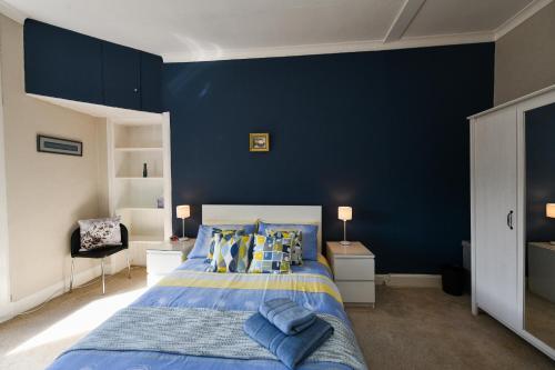 1 dormitorio azul con 1 cama con paredes azules en Brae View Coastal Gem, en Largs