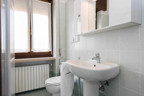 トッリ・デル・ベーナコにあるOrtagliaの白いバスルーム(洗面台、トイレ付)