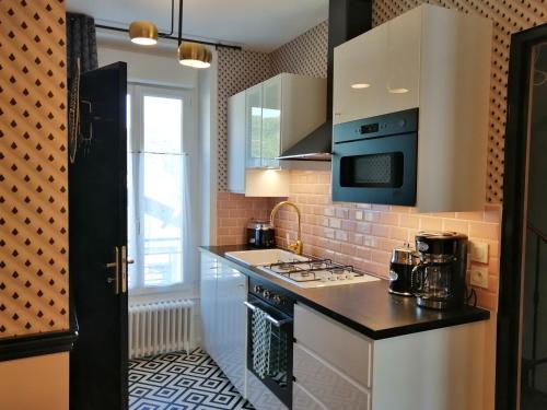 a kitchen with a sink and a stove top oven at Villa Étienne in Le Mont-Dore