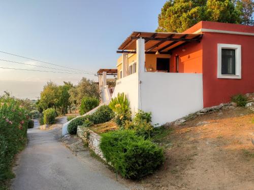 a small house on a hill next to a road at Pernakria in Skala Rachoniou