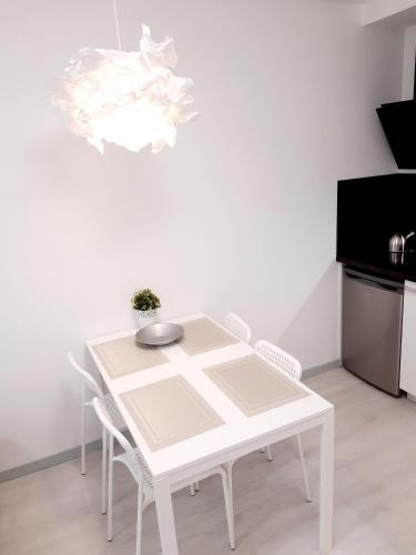 a white table and chairs in a white kitchen at Apartments Daina in Jūrmala