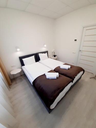 a bedroom with a large bed with two towels on it at Apartments Daina in Jūrmala