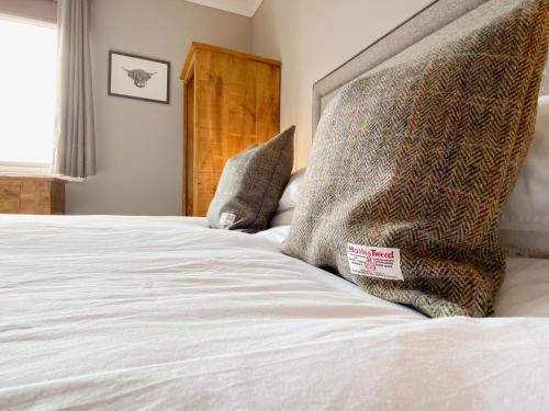 a bed with two pillows on top of it at Cairngorm Guest House in Aviemore