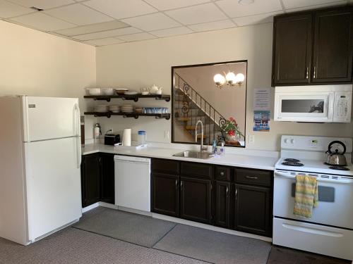 a kitchen with a white refrigerator and a sink at Paradise Inn On the Beach in Port Elgin