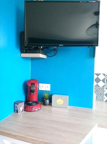 a desk with a television and a red blender at LP Appart in Annecy