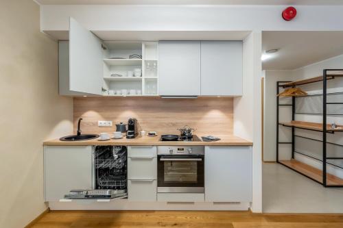 a kitchen with white cabinets and a counter at Gustav Apartments - City Center Comfort in Tartu