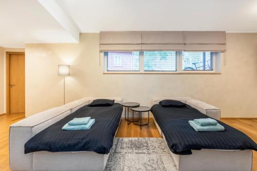 1 dormitorio con 2 camas y mesa en Gustav Apartments - City Center Comfort en Tartu