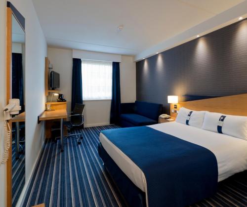 a hotel room with a large bed and a desk at Holiday Inn Express Hasselt, an IHG Hotel in Hasselt