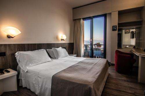een hotelkamer met een groot bed en een balkon bij Hotel Concorde in Arona