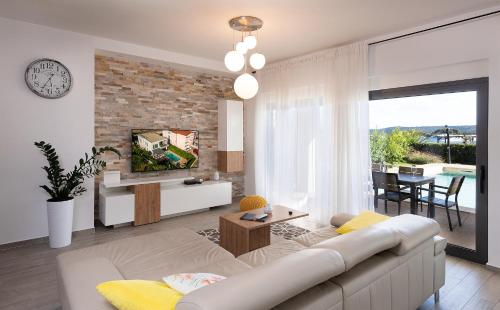 a living room with a couch and a tv at Villa Lu-Ma Beachfront with Heated Pool in Turanj