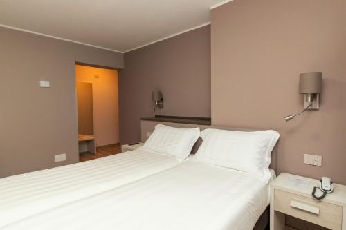 a bedroom with a large bed with white sheets at Er Mirin - Il Mulino di Carcare Hotel in Carcare