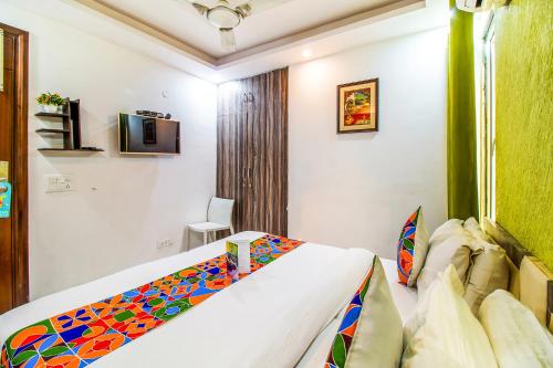 a bedroom with a bed and a tv on the wall at FabHotel A 97 in New Delhi