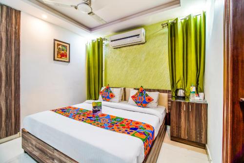 a bedroom with a large bed with green curtains at FabHotel A 97 in New Delhi