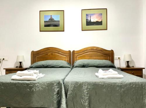 1 dormitorio con 2 camas y toallas. en Hostal Carlos 2 en La Línea de la Concepción