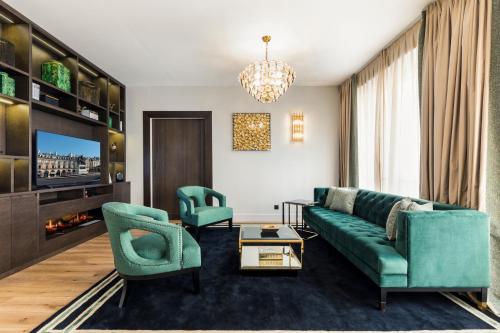 ein Wohnzimmer mit einem grünen Sofa und 2 Stühlen in der Unterkunft Luxury Apartment Paris Louvre II in Paris