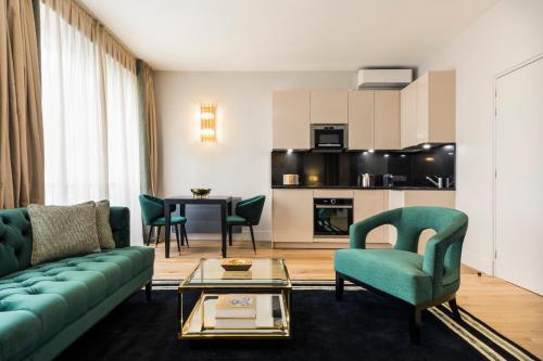 ein Wohnzimmer mit einem Sofa, Stühlen und einem Tisch in der Unterkunft Luxury Apartment Paris Louvre II in Paris